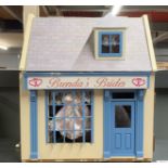 A dolls house complete bridal shop with mannequins, dresses, dolls, etc.