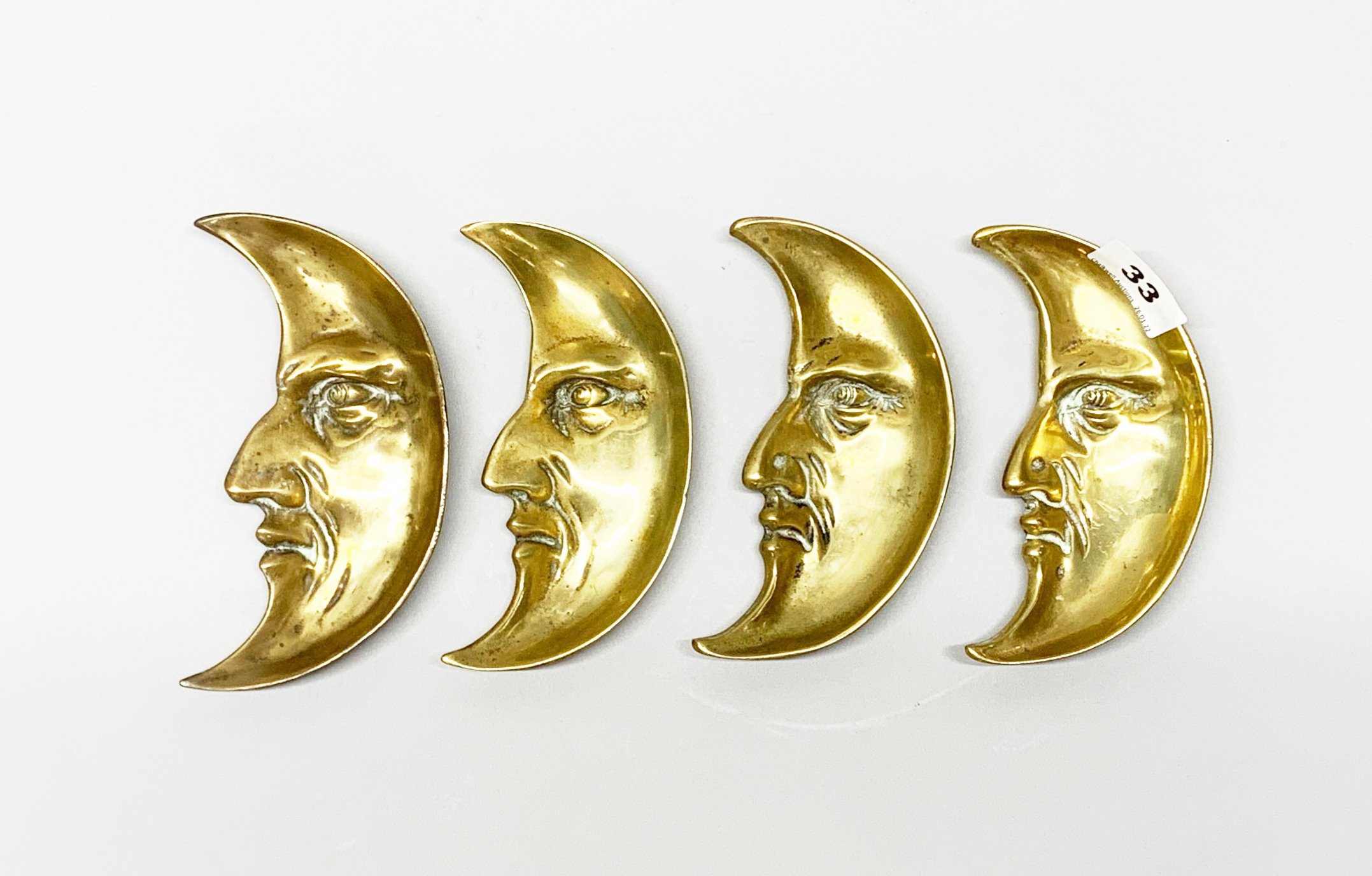 A set of four 19th century brass 'man in the moon' dishes, Dia. 15cm.