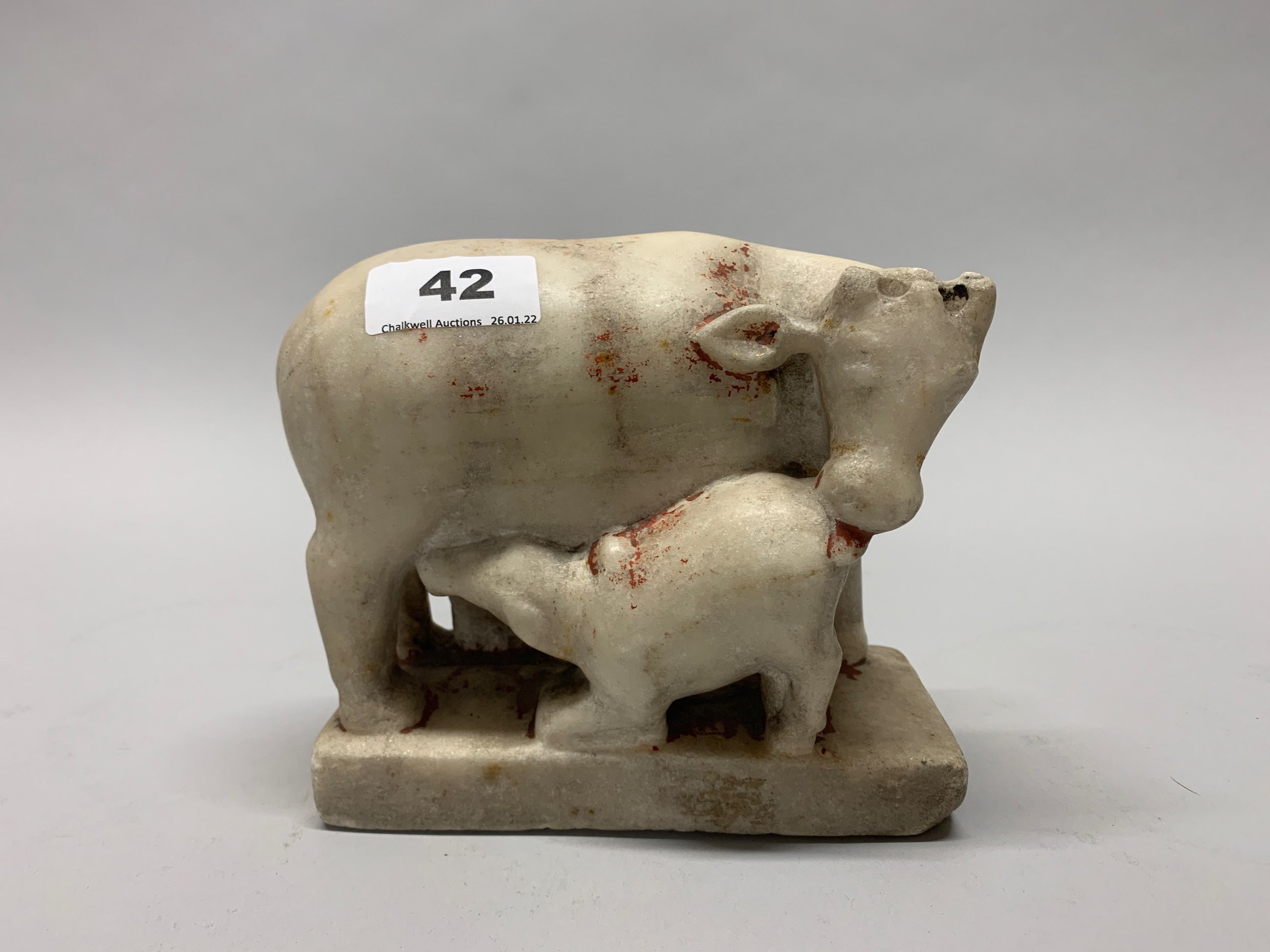 An 18th/ early 19th century Asian carved marble figure of a cow and calf with two female attendants,