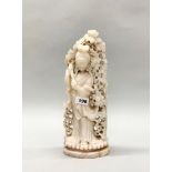 A large 19th/ early 20th century Chinese carved pink soapstone figure of a woman surrounded by