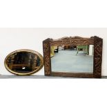 An early carved oak framed mirror, 86 x 65cm and a 1920's oval mirror, W. 75cm.