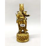 A Tibetan gilt bronze figure of a standing guardian deity, H. 29cm.