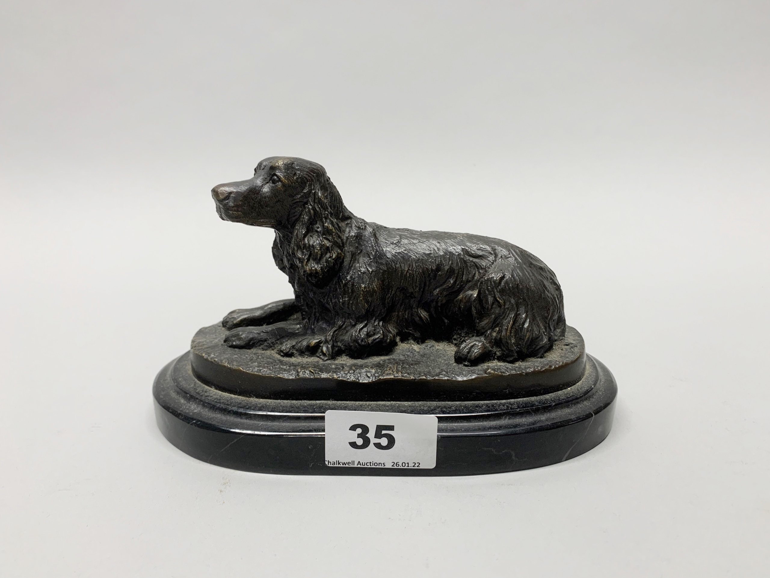 A bronze figure of a spaniel on a black marble base, L. 19cm H. 10.5cm.