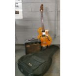 A vintage electric guitar and case with guitar stand and a Rhino amplifier.