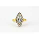 A hallmarked 18ct yellow gold cluster ring set with a marquise cut aquamarine surrounded by