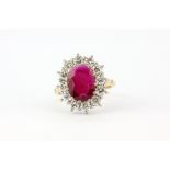 A hallmarked 18ct yellow gold cluster ring set with a large oval cut ruby, approx. 3ct+,