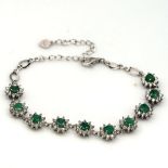 A 925 silver bracelet set with round cut emeralds and white stones, L. 20cm.