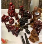 Two Oriental carved wooden figures and a group of further resin figures.