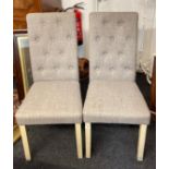 A pair of contemporary button backed bedroom chairs.