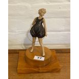 An Art Deco style figure of the Hoop Girl on a wooden base.