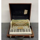 A Hohner Virtuola III piano accordion and case.