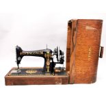 A cased early Singer sewing machine.