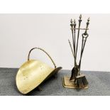 A gilt brass log basket with a set of brass fire irons and stand.