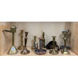 A group of mixed brass, pewter, copper and iron candlesticks, lamps and spout lamps etc, tallest