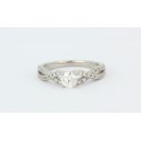 An 950 platinum solitaire ring set with a brilliant cut diamond and diamond set shoulders, approx.