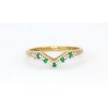 A hallmarked 9ct yellow gold wishbone ring set with round cut emeralds and diamonds, (Q.5).