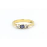 An antique 18ct yellow gold ring set with an oval cut sapphire and two round cut diamonds, (G.5).