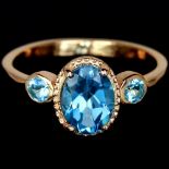 A 925 silver rose gold gilt ring set with oval cut blue topaz, (M).