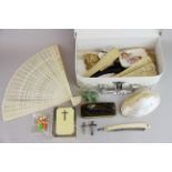 A case of interesting small items, including bone and celluloid fans.