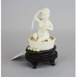 A 1920's/30's Chinese carved ivory figure of a girl bathing on a purpose made wooden stand, H.