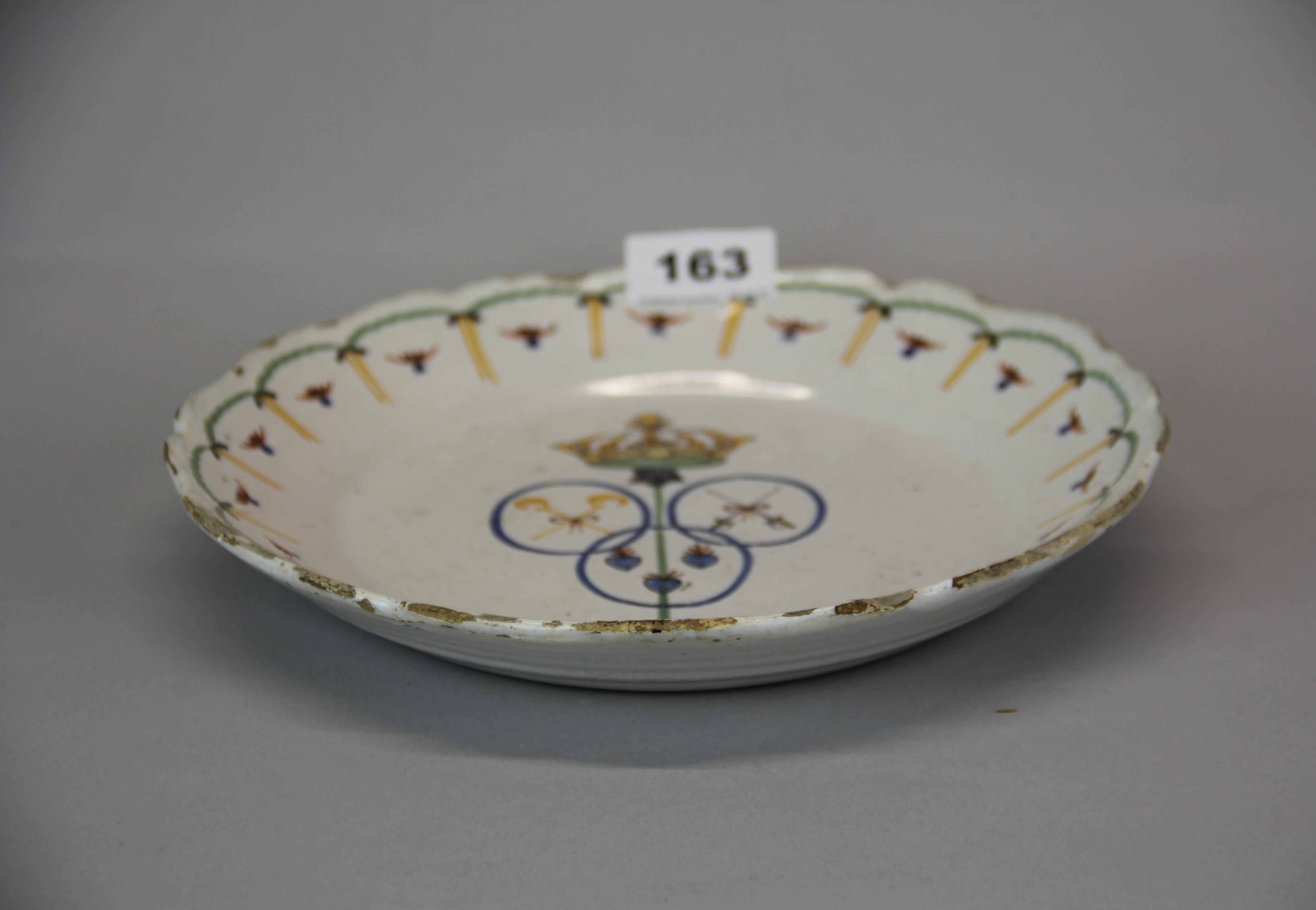 An 18th century French hand painted tin glazed pottery plate with armorial design to the centre, - Image 2 of 3