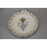 An 18th century French hand painted tin glazed pottery plate with armorial design to the centre,