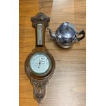 A 1930's carved oak barometer, H. 62cm with a chromium plated teapot.