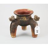 An early Peruvian terracotta three legged vessel, ornamented with animal heads and a ball rattle
