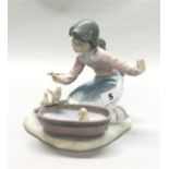 A porcelain Lladro figurine of a girl playing with ducklings, H. 15cm. (slightly A/F).