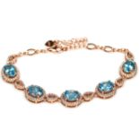 A 925 silver rose gold gilt bracelet set with oval cut blue topaz and white stones, L. 18cm.