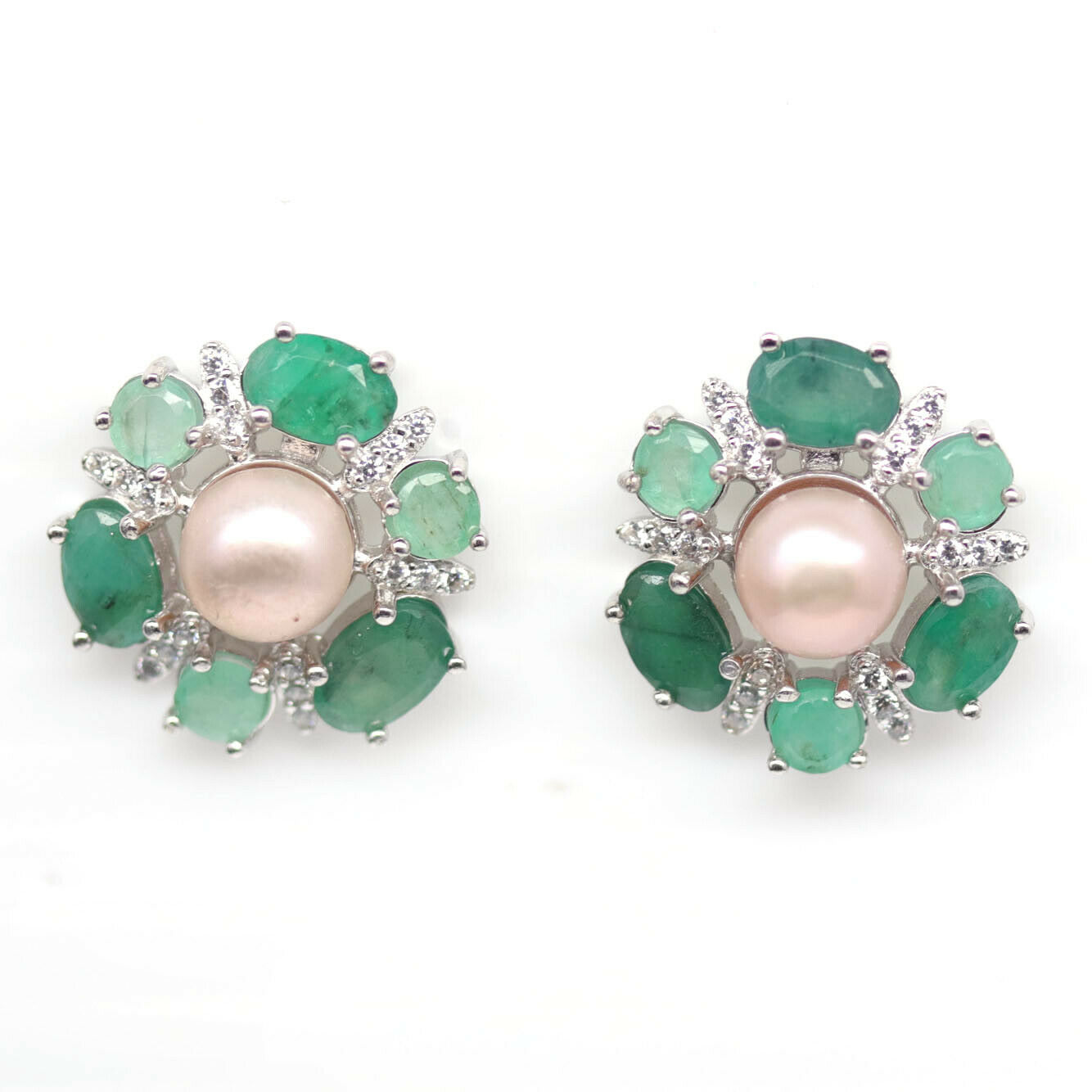 A pair of 925 silver cluster earrings set with oval cut emeralds and white stones, with creamy