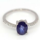 A 925 silver ring set with an oval cut sapphire and white stone set shoulders, (L.5). Condition NEW,