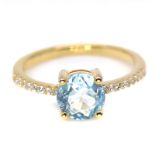 A 925 silver gilt ring set with a round Swiss blue topaz and white stone set shoulders, (L.5).