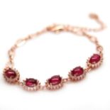 A 925 silver rose gold gilt bracelet set with cabochon cut rubies and white stones, L. 18cm.