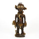 An African tribal clay figure adorned with reed string and shell and glass beads, H. 23cm.