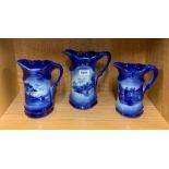 A set of three graduated water jugs, largest 22cm.