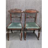 A pair of carved regency mahogany chairs with drop in and cane seats.
