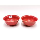 An interesting pair of Chinese orange/red glazed porcelain rice bowls, Dia. 16cm.