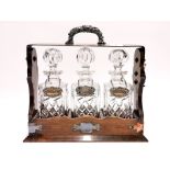 A silver plated and mahogany tantalus stand with three cut glass decanters and three hallmarked