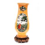A Chinese hand enamelled porcelain vase, H. 41cm, on a carved wooden base.