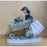 A Lladro figure of a girl with puppies in a wheelbarrow, H. 22cm.