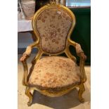 An upholstered gilt wood armchair.