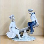 A large Lladro figure of a boy and girl on a seesaw, H. 25cm.