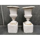 A pair of vintage painted cast iron garden urns on concrete pedestals, H. 61cm.