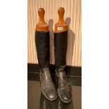 A pair of leather riding boots and wooden boot jacks, boot L. 30cm, H. 63cm.