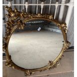 An ornate circular gilt framed mirror, H. 112cm.