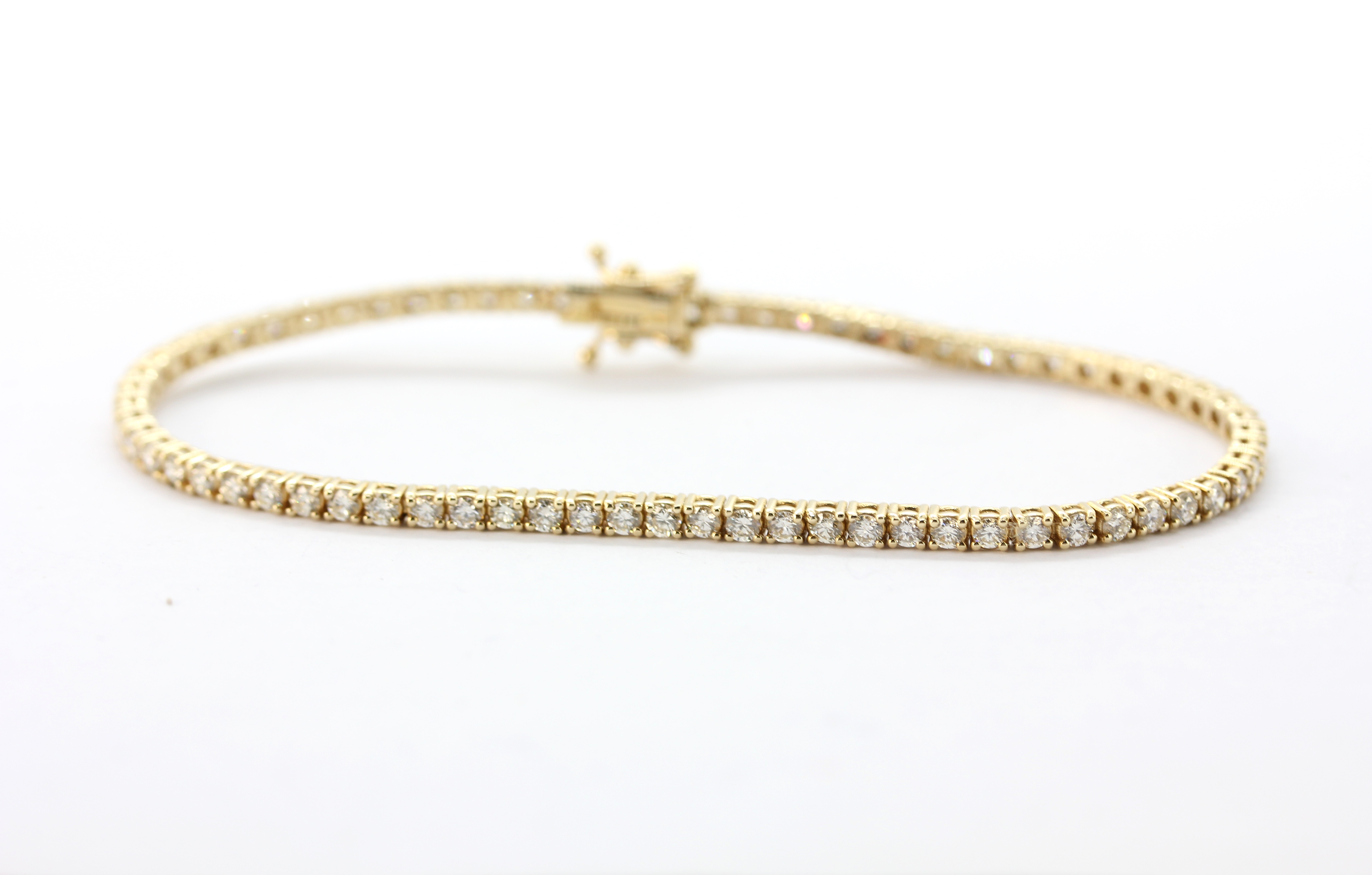 A yellow metal (tested 14ct gold) tennis bracelet set with brilliant cut diamonds, approx. 2.56ct,