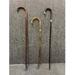 A group of three silver mounted natural wood walking sticks.