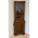 A mahogany veneered corner cabinet, W. 65cm. H. 184cm.