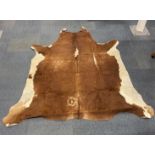 A cattle skin rug/ throw , W. 165cm, L. 165cm.